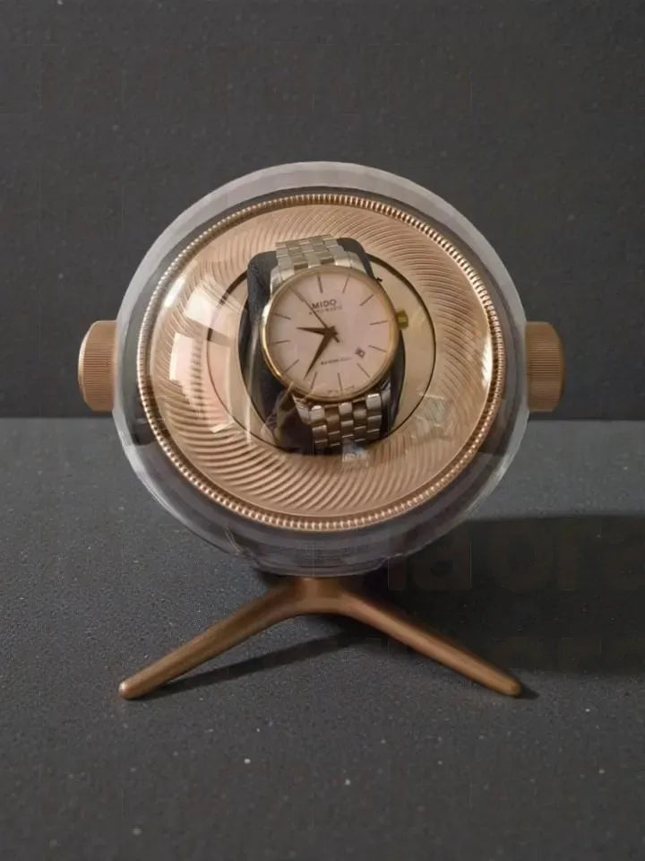 Vintage watch inside a round, metallic display case on a dark background