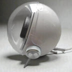 White spherical device with a black interior on a gray background