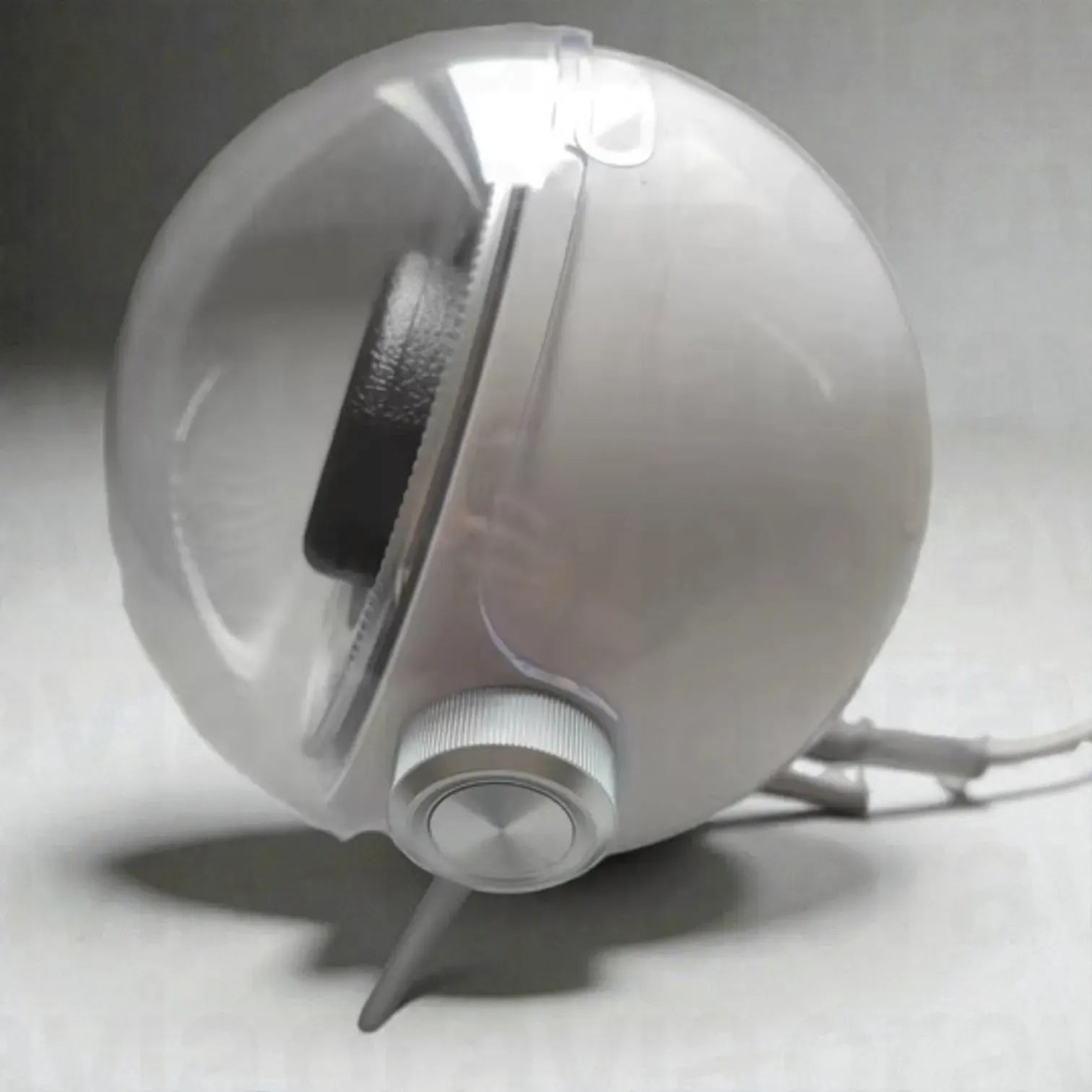 White spherical device with a black interior on a gray background
