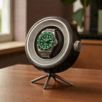 Watch in a winder on a wooden surface with a blurred background