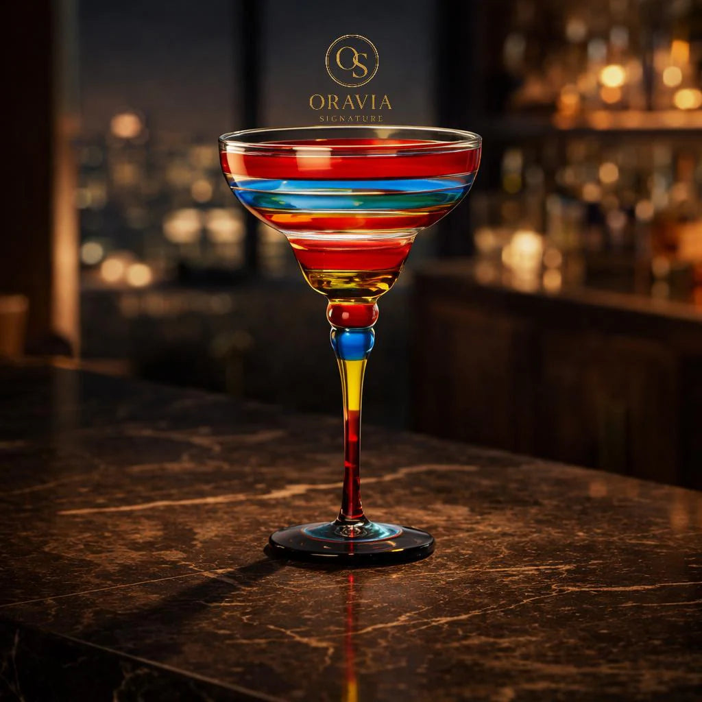 Colorful striped cocktail glass on a bar counter with Oravia logo.
