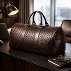 Brown woven duffel bag on a desk with office items in the background
