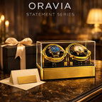 Oravia Statement Series watch display with two watches in a gold case on a dark surface.