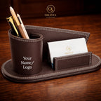 Brown leather desk organizer with pen holder and business card holder on a wooden surface, featuring the Oravia brand.