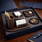 Oravia leather desk set with pen holder, business card holder, and coin tray on a wooden surface.