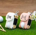 Two golf ball and tee sets in personalized cases on a grassy surface with a wooden background.