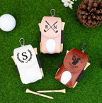 Three golf ball holders with personalized designs on a grass background