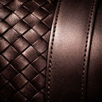 Close-up of brown leather with woven pattern and stitching