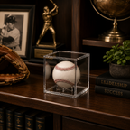 Baseball in a clear cube on a wooden shelf with books, a globe, and a baseball glove.