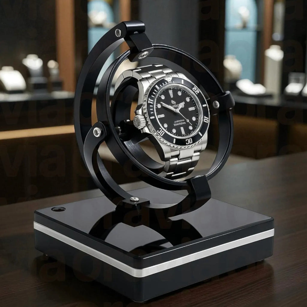 Black and silver watch  winder on a decorative stand with a blurred background