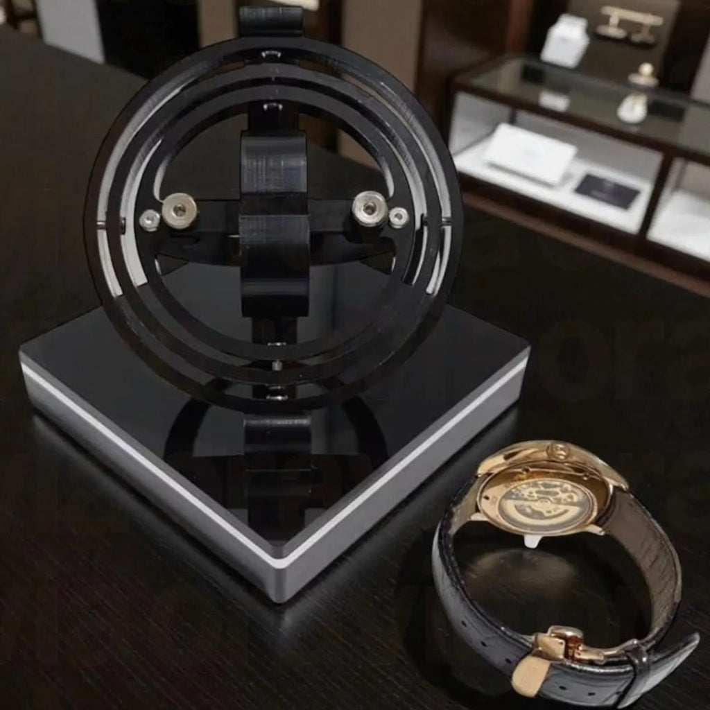 Black watch winder display stand with a watch on a wooden surface